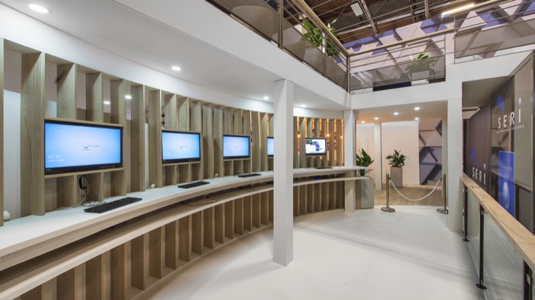 Espace de démonstration avec postes informatiques intégrés dans un mobilier en bois
